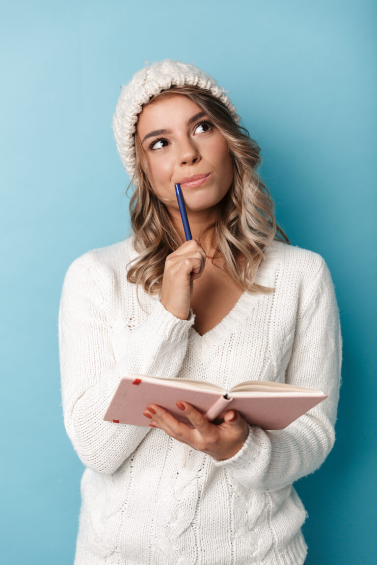 portrait of nice dreaming woman looking upward and making notes