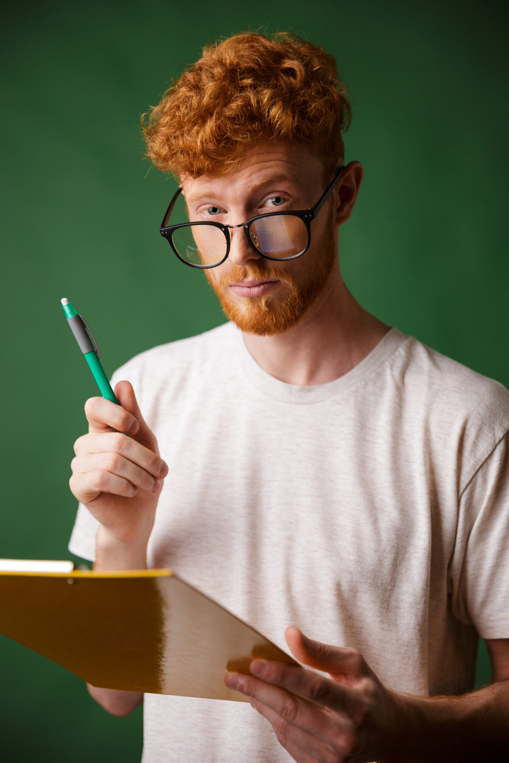 smart readhead bearded man in white tshirt holding folder and pe